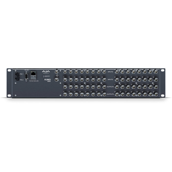 AJA KUMO 3232 compact 32x32 3G-SDI router with full-size BNC connectors, front-panel buttons, and LCD display in a 2RU rack-mounted unit.