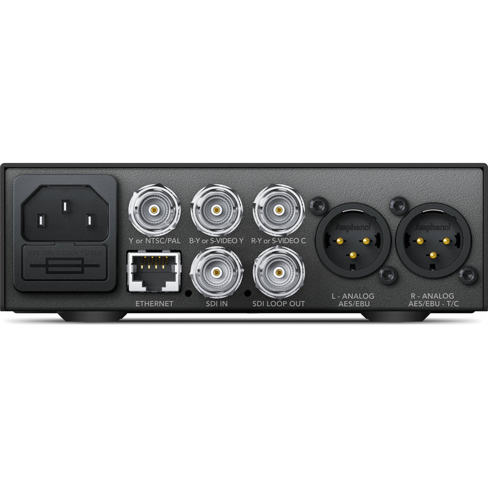 The Blackmagic Design Teranex Mini SDI to Analog 12G Converter is a compact, rectangular device with a matte black finish. The front panel features a USB port and ventilation grilles, while the rear panel includes a 12G-SDI input, a loop-through SDI output, component, S-Video, and composite analog video outputs, an Ethernet port, and XLR audio outputs. This design facilitates professional video and audio signal conversion in broadcast and post-production environments.