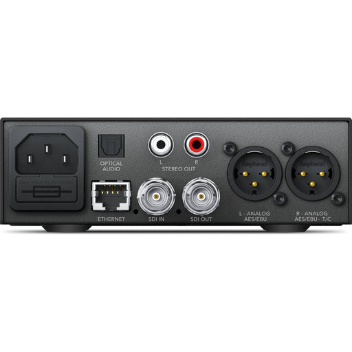 The Blackmagic Design Teranex Mini SDI to Audio 12G Converter is a compact, rectangular device with a matte black finish. The front panel features a USB port and ventilation grilles, while the rear panel includes a 12G-SDI input, a loop-through SDI output, balanced XLR audio outputs, unbalanced RCA audio outputs, an optical audio output, an Ethernet port, and a standard IEC power input. This design facilitates professional audio de-embedding from SDI signals in broadcast and post-production environments.