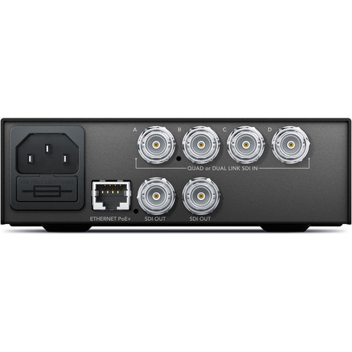 The Blackmagic Design Teranex Mini Quad SDI to 12G-SDI Converter is a compact, rectangular device with a matte black finish. The front panel features a USB port and ventilation grilles, while the rear panel includes four 12G-SDI inputs, a single 12G-SDI output, an Ethernet port, and a standard IEC power input. This design facilitates the conversion of Quad-Link SDI sources to a single 12G-SDI output, streamlining connectivity in professional broadcast and post-production environments.