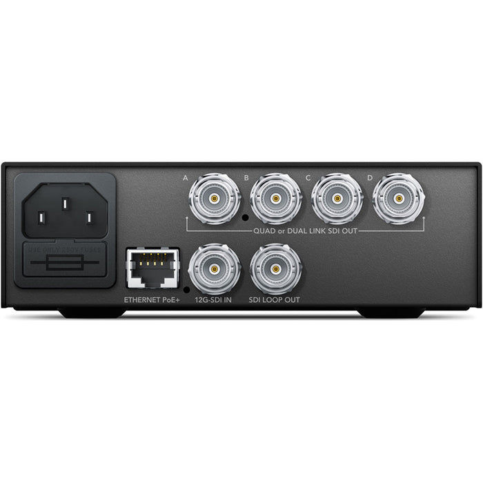 The Blackmagic Design Teranex Mini 12G-SDI to Quad SDI Converter is a compact, rectangular device with a matte black finish. The front panel features a USB port and ventilation grilles, while the rear panel includes a 12G-SDI input, a 12G-SDI loop output, four 3G-SDI outputs, an Ethernet port, and a standard IEC power input. This design facilitates the conversion of a single 12G-SDI signal into four 3G-SDI outputs, enabling compatibility with equipment that utilizes Quad-Link SDI connections.