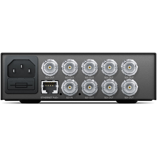 The Blackmagic Design Teranex Mini SDI to DisplayPort 8K HDR Converter is a compact, rectangular device with a matte black finish. The front panel features a color LCD screen, control buttons, and a rotary knob for easy navigation and settings adjustment. The rear panel includes four 12G-SDI inputs, four 12G-SDI loop outputs, two full-size DisplayPort outputs, one USB-C DisplayPort output, two analog audio outputs via RCA connectors, an Ethernet port, and a standard IEC power input.