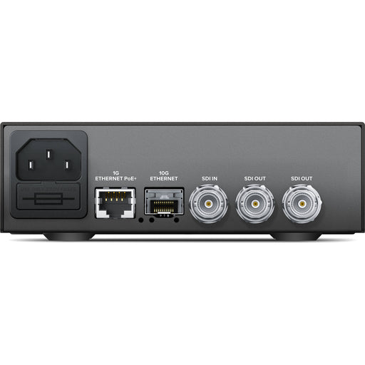 The Blackmagic Design Teranex Mini IP Video 12G Converter is a compact, rectangular device with a matte black finish. The front panel features a USB port and ventilation grilles, while the rear panel includes a 12G-SDI input, two 12G-SDI outputs, a Gigabit Ethernet port, an SFP+ cage for optional 10G Ethernet modules, and a standard IEC power input. This design facilitates bi-directional conversion between 12G-SDI signals and IP video streams, supporting video formats up to DCI 4K at 60p. 